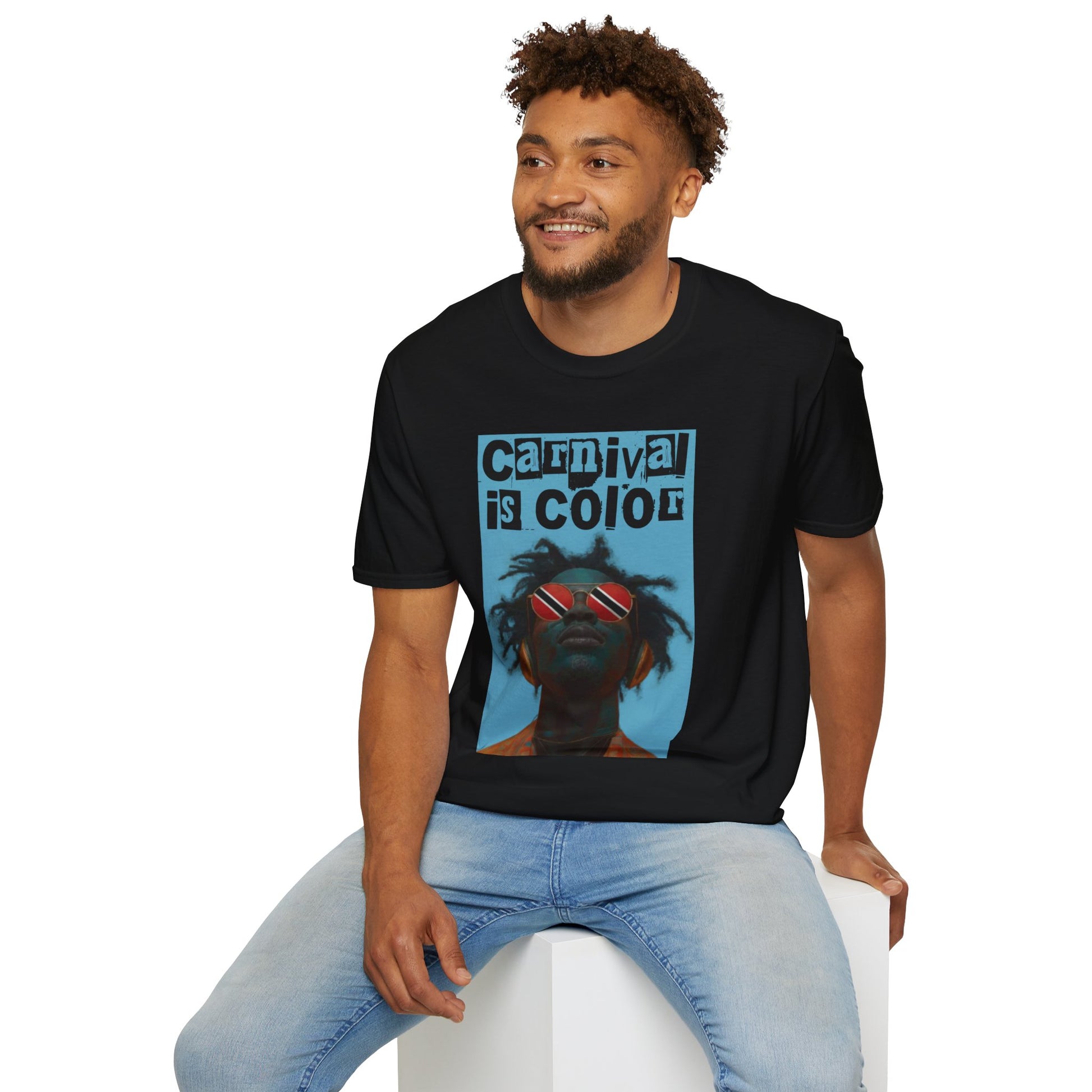 Man wearing a black Carnival is Color Trinidad and Tobago t-shirt, sitting in front of a white background