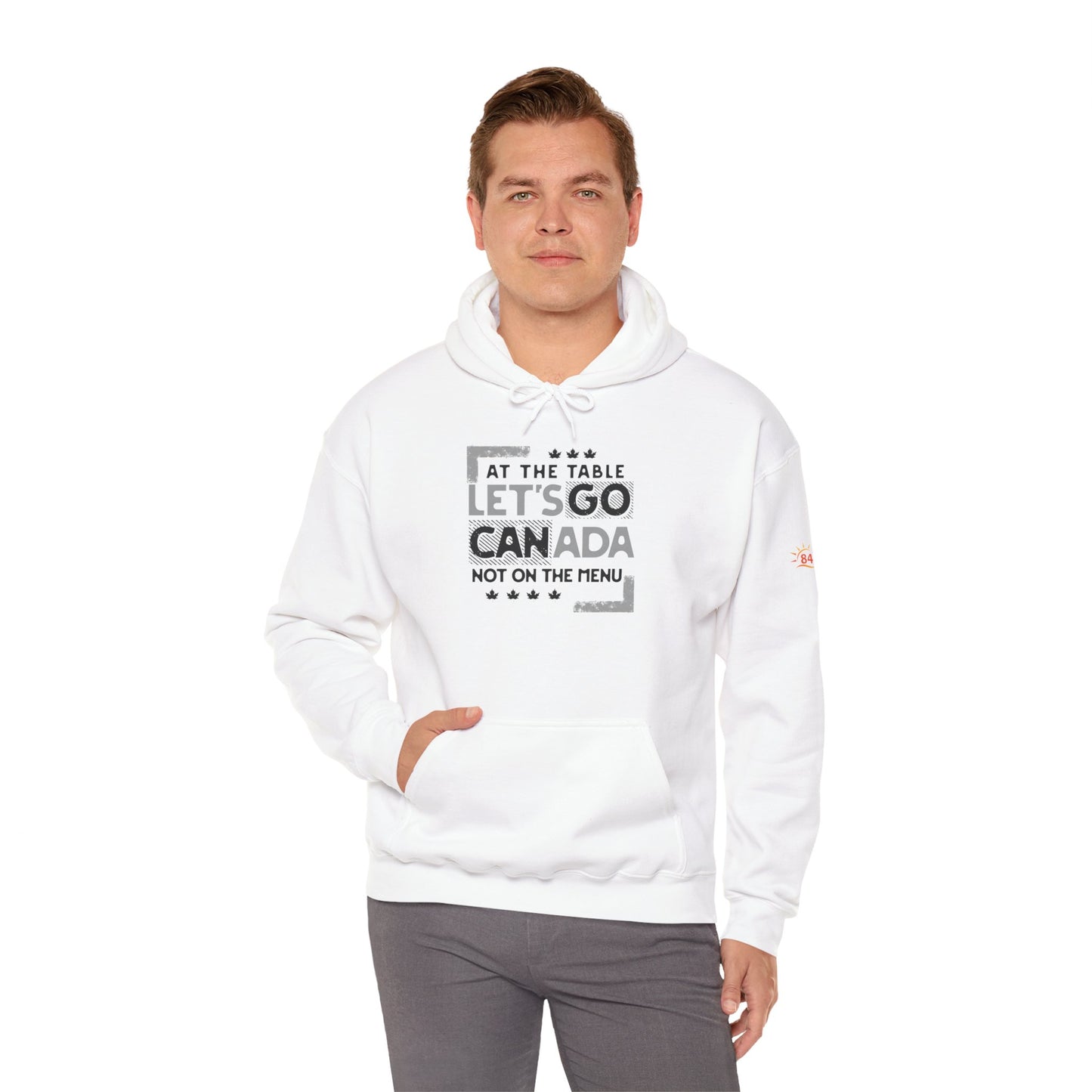 Man wearing a white hoodie with text design, At the table, Let's go Canada, Not on the menu, standing indoors against a white background.