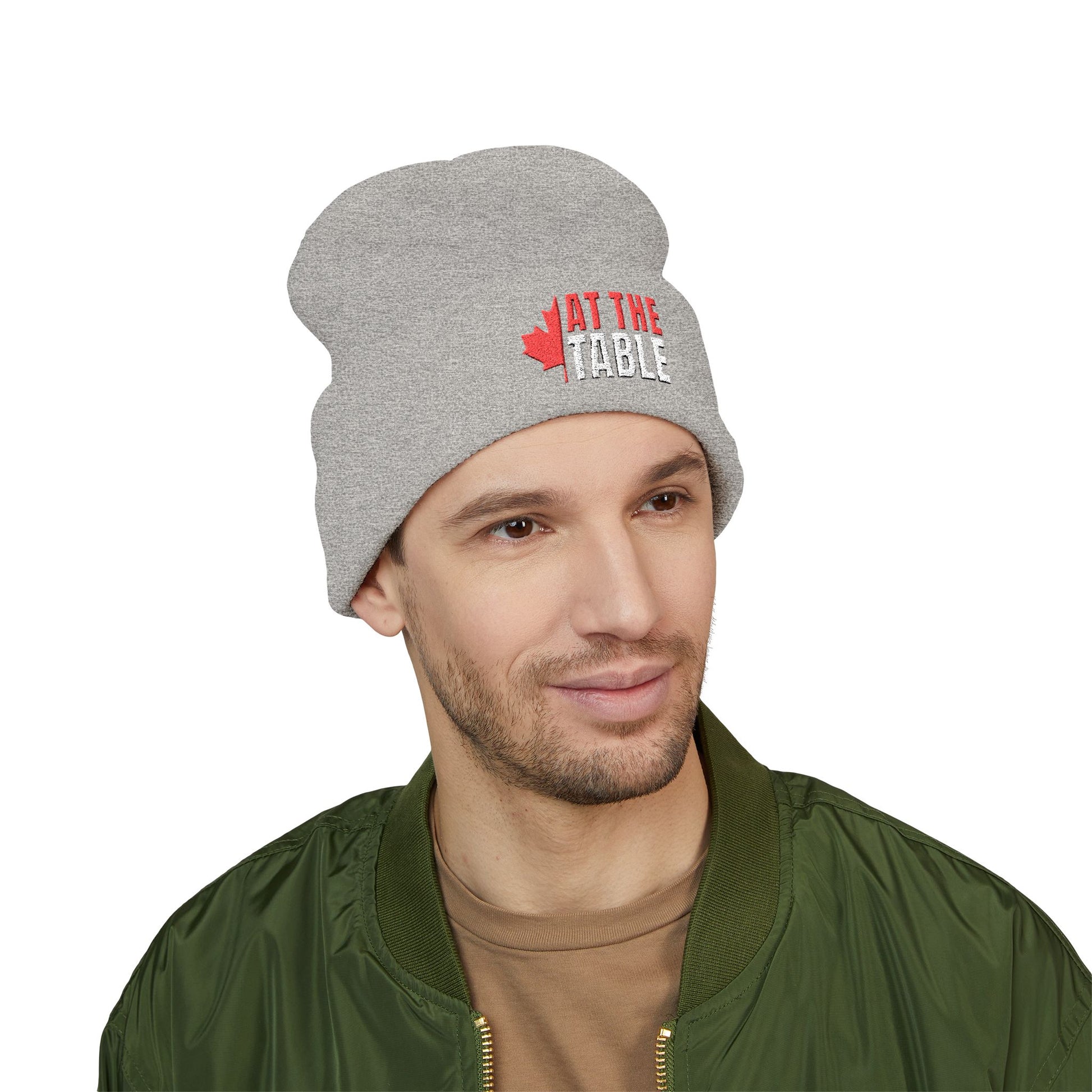 Man wearing a gray beanie with text and a maple leaf design on a white background