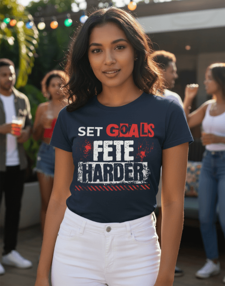 Woman wearing a navy blue t-shirt with text, Set Goals Fete Harder, at a party with people in the background