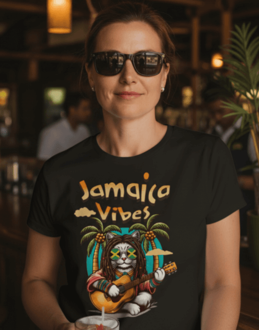 Woman standing in a bar wearing a black t-shirt with Jamaica Vibes text and Jamaica flag reggae inspired graphic. 