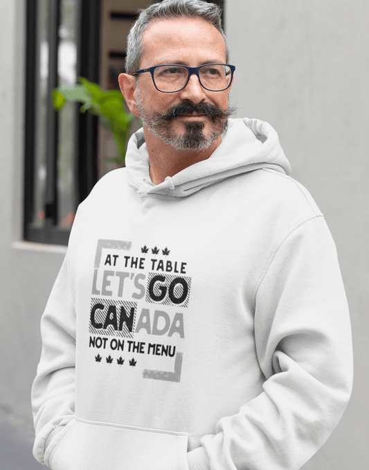 Man wearing a white hoodie with text design, At the table, Let's go Canada, Not on the menu, standing outdoors.