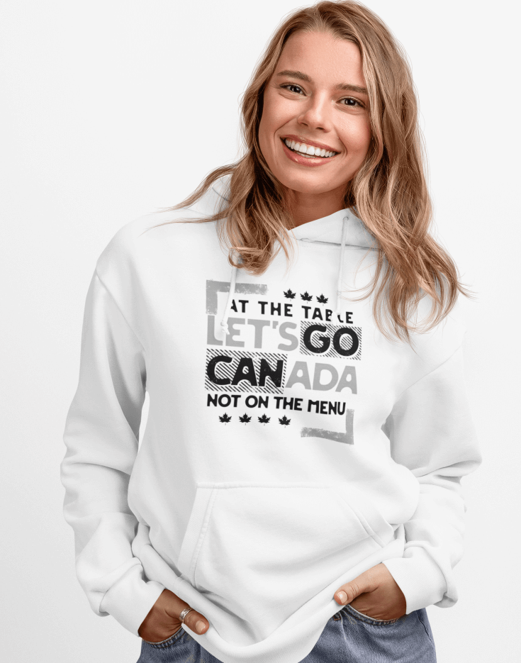 Woman wearing a white hoodie with text design, At the table, Let's go Canada, Not on the menu, standing indoors.