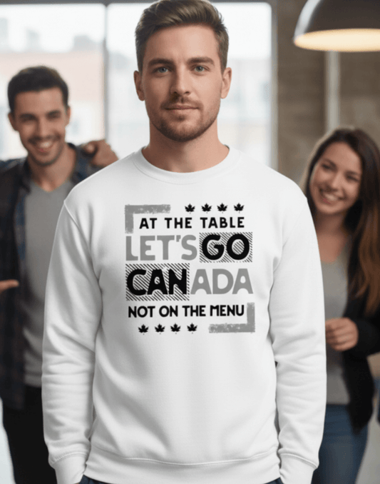 Man wearing a white sweatshirt with text, At the table, Let's Go Canada, Not on the menu, in an indoor setting