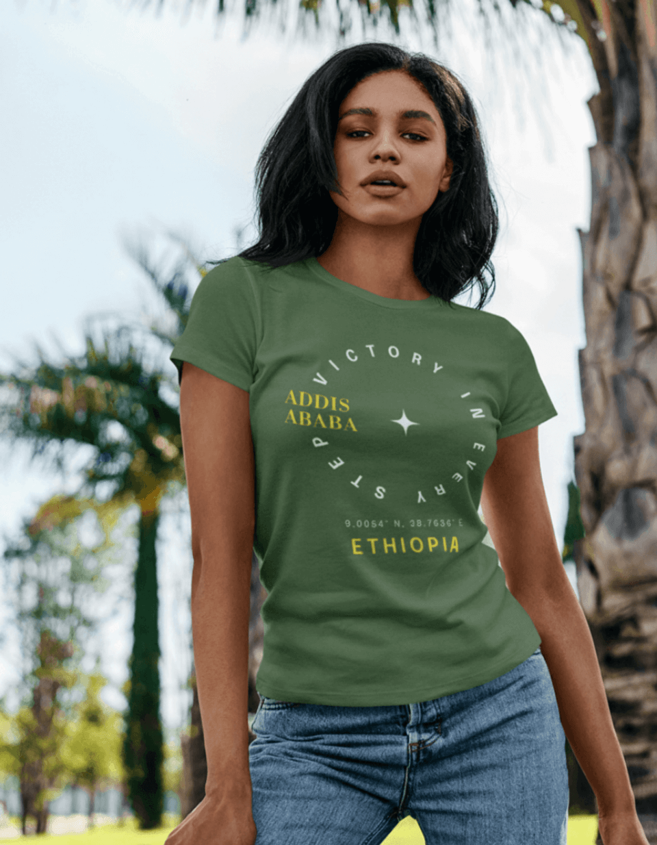 Woman wearing a green Ethiopian, Addis Ababa, minimalist, t-shirt with yellow and white text standing outdoors with trees in the background