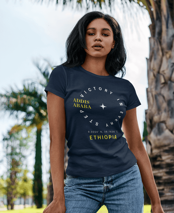 Woman wearing a navy blue t-shirt with 'Addis Ababa, Ethiopia' printed on it, standing outdoors.