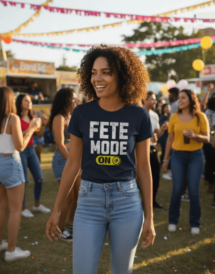 Woman wearing a navy blue t-shirt with 'Fete Mode ON' text at a festive outdoor event.