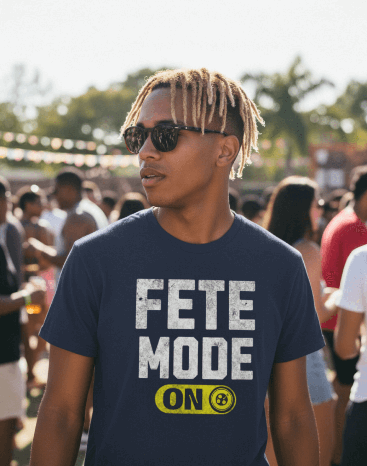 Man wearing a navy blue t-shirt with 'Fete Mode ON' text at a festive outdoor event.