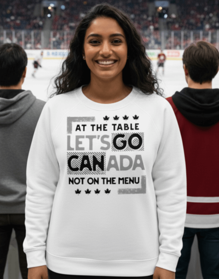 Woman wearing a white sweatshirt with text, At the table, Let's Go Canada, Not on the menu, in an indoor hockey game setting