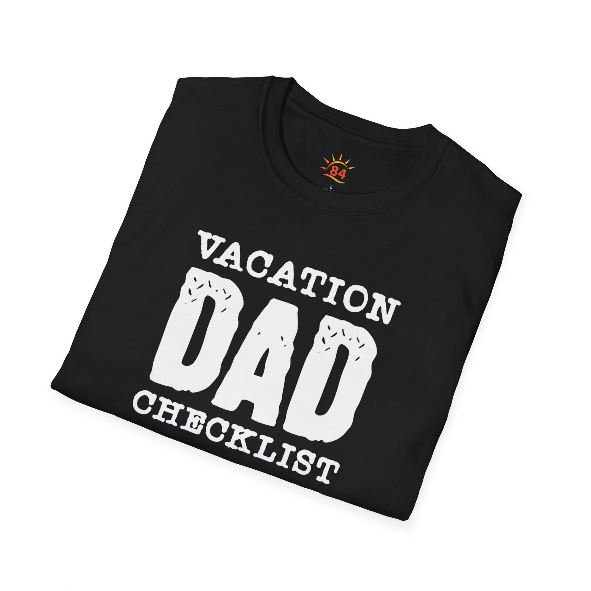 A folded black t-shirt with 'VACATION DAD CHECKLIST' text and bold text and graphics
