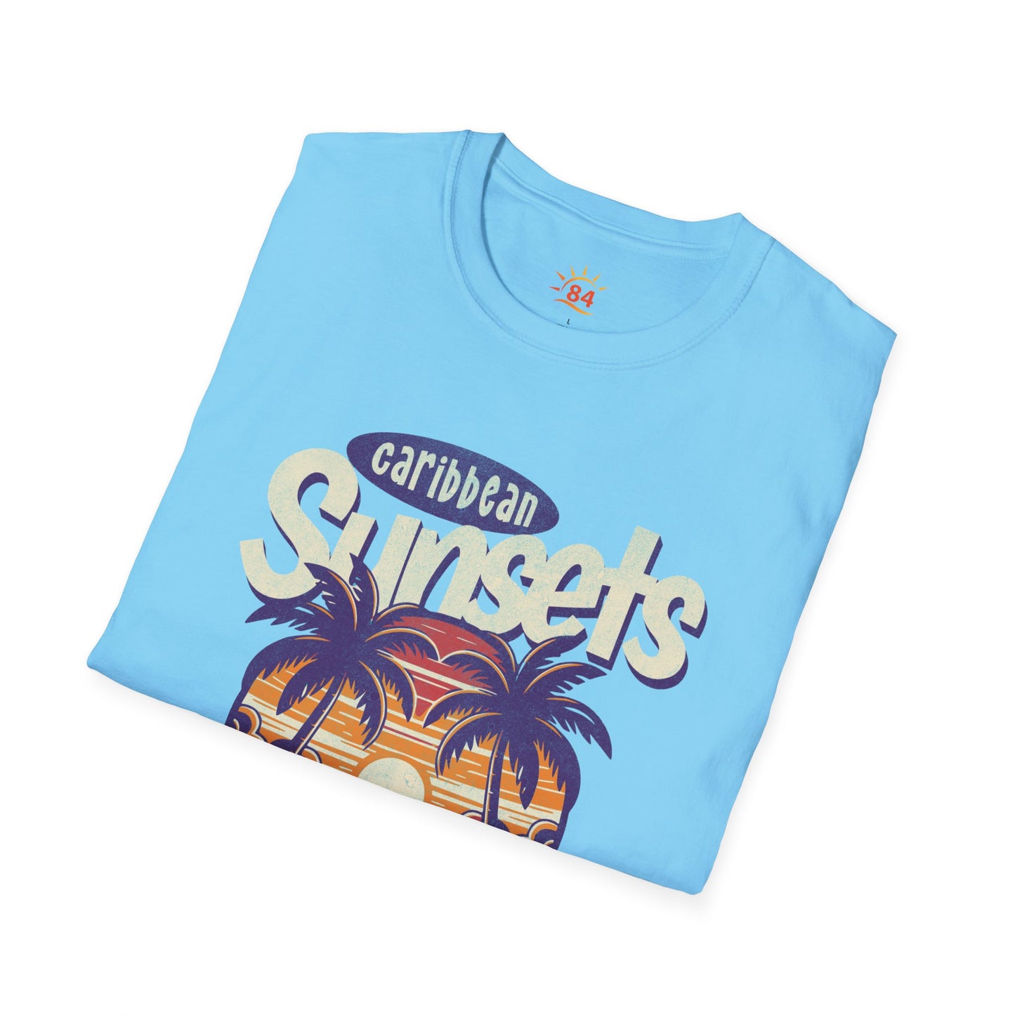 A folded sky blue t-shirt that says Caribbean Sunsets, Rum Punch Dreams with a beach sunset graphic.