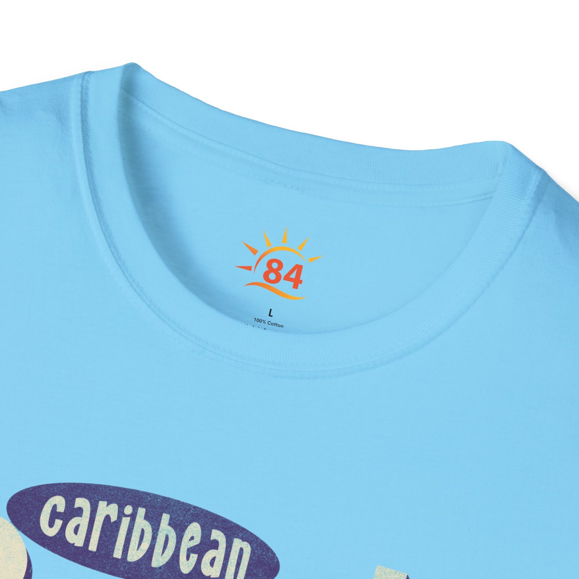 A folded sky blue t-shirt that says Caribbean Sunsets, Rum Punch Dreams with a beach sunset graphic.