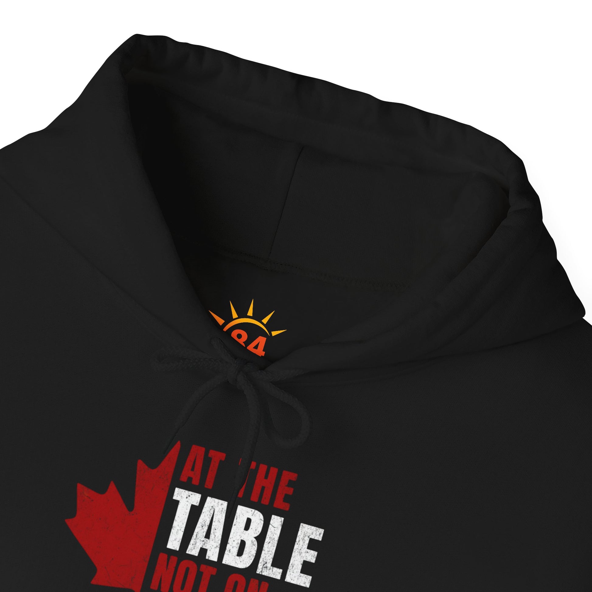 A folded black hoodie with a red and white graphic design. We are at the table not on the menu